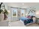 Charming bedroom featuring blue walls, a large window with natural light, and stylish furnishings at 1613 Caldwell Bend Ln, Dacula, GA 30019