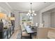 Bright dining room featuring a modern chandelier, decor, and an adjacent kitchen and living area at 1613 Caldwell Bend Ln, Dacula, GA 30019