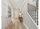 Inviting hallway with light hardwood floors, wood decor, and a staircase with black metal railings at 1613 Caldwell Bend Ln, Dacula, GA 30019