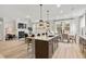 Open kitchen island with seating, modern appliances, and a view into the living area at 1613 Caldwell Bend Ln, Dacula, GA 30019