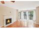 Living room with fireplace and natural light flowing through a sliding glass door, and hardwood flooring at 2303 Pine Heights Ne Dr, Atlanta, GA 30324