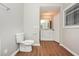 Bathroom featuring a toilet, vanity, mirror, and window which provide natural light and ventilation at 2938 Parkwood Rd, Snellville, GA 30039