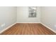 This bedroom has wood flooring, a window with blinds, and neutral-colored walls at 2938 Parkwood Rd, Snellville, GA 30039
