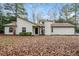 Traditional single-story home with white siding, black door, chimney, and a lawn covered in fall leaves at 2938 Parkwood Rd, Snellville, GA 30039