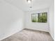 A secondary bedroom featuring neutral carpet and a bright window at 49 Country Ct, Alpharetta, GA 30005