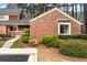 Charming brick townhome featuring landscaped front yard and walkway to the entrance at 49 Country Ct, Alpharetta, GA 30005