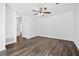 Bright living room with dark wood flooring, white walls, and a ceiling fan at 49 Country Ct, Alpharetta, GA 30005