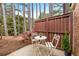 Private patio area includes a white table and chairs, bordered by a privacy fence and trees at 49 Country Ct, Alpharetta, GA 30005