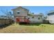 A two story home and wood deck overlook a grassy lawn with partial fencing at 7324 Drake Ave, Lithonia, GA 30058