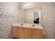 Bathroom with double vanity, floral wallpaper, and large mirror at 7324 Drake Ave, Lithonia, GA 30058