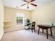 A well-lit room with neutral walls features a chair, shelving, desk, and table, next to a window at 7324 Drake Ave, Lithonia, GA 30058