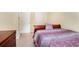 A well-lit bedroom showcases carpet flooring and a bed with patterned bedding, next to a wood dresser at 7324 Drake Ave, Lithonia, GA 30058