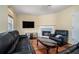 Inviting living room featuring hardwood floors, fireplace, and a comfortable black leather sofa set at 7324 Drake Ave, Lithonia, GA 30058