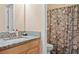 Well-maintained bathroom with granite countertop, wood cabinets, and floral shower curtain at 765 Rock Ln, Mcdonough, GA 30253