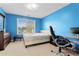 Bright bedroom with blue walls, carpeted floors, and a large window overlooking a leafy vista at 765 Rock Ln, Mcdonough, GA 30253