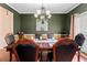 Formal dining room featuring dark green walls, elegant lighting, and a hardwood table at 765 Rock Ln, Mcdonough, GA 30253