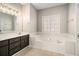 Bathroom with a large soaking tub, dark vanity, and a neutral color scheme at 1092 Shumard Ln, Mcdonough, GA 30252