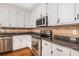 Close-up of the kitchen countertops, stainless steel oven, and white cabinets with tile backsplash at 1092 Shumard Ln, Mcdonough, GA 30252