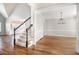 Spacious living room featuring hardwood floors, a staircase with rod iron balusters, and stylish lighting at 1092 Shumard Ln, Mcdonough, GA 30252