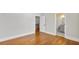 Light-filled bedroom with hardwood floors showcases an open doorway to the staircase and a bathroom at 25 Mountain Crest Dr, Oxford, GA 30054
