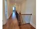 Hallway with hardwood floors featuring access to rooms, a staircase, and wood-iron railings at 25 Mountain Crest Dr, Oxford, GA 30054