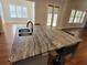 Kitchen island features marble countertops, stainless steel sink and seating at 25 Mountain Crest Dr, Oxford, GA 30054