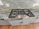 Close up of stainless steel cooktop with gray granite counters and shaker cabinets at 25 Mountain Crest Dr, Oxford, GA 30054