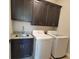 Laundry area featuring dark cabinets, granite countertops, and modern washer and dryer at 25 Mountain Crest Dr, Oxford, GA 30054