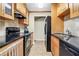 Galley kitchen features black appliances, wooden cabinets and dark countertops at 1166 Booth Sw Rd # 605, Marietta, GA 30008