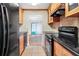 Galley kitchen features black appliances, wooden cabinets and tile backsplash at 1166 Booth Sw Rd # 605, Marietta, GA 30008