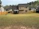 Expansive fenced-in backyard with lush lawn, mature trees, and a charming gazebo seating area at 2469 Briar Knoll Rd, Lithonia, GA 30058