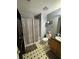 This clean bathroom includes a tub/shower, black and white tile floors and neutral vanity at 2469 Briar Knoll Rd, Lithonia, GA 30058