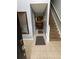Hallway with neutral tile floors, access to stairs, and a view into the kitchen at 2469 Briar Knoll Rd, Lithonia, GA 30058