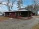 Side view of house with shingle siding, red trim, carport, and gravel driveway at 3844 Oglesby Rd, Powder Springs, GA 30127