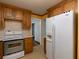 Kitchen with wooden cabinets, white appliances, and a full size refrigerator at 3844 Oglesby Rd, Powder Springs, GA 30127