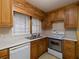 Kitchen featuring wooden cabinets, white appliances, and laminate countertops at 3844 Oglesby Rd, Powder Springs, GA 30127