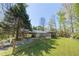 Spacious backyard with mature trees, a gazebo, shed, and a wooden fence at 5369 Blue Grass Ln, Sugar Hill, GA 30518