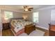 Traditional bedroom featuring hardwood floors, a ceiling fan, and neutral wall color at 5369 Blue Grass Ln, Sugar Hill, GA 30518