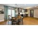 Inviting dining area with hardwood floors, elegant lighting, and a view into the modern kitchen with gray cabinets at 5369 Blue Grass Ln, Sugar Hill, GA 30518