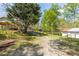 Long gravel driveway leading to the house, carport, outbuilding and surrounded by trees at 5369 Blue Grass Ln, Sugar Hill, GA 30518