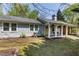 Charming home with a covered porch and yellow front door, surrounded by lush greenery and a well-maintained lawn at 5369 Blue Grass Ln, Sugar Hill, GA 30518