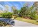 Charming home nestled amongst mature trees featuring a well-manicured lawn and a winding driveway at 5369 Blue Grass Ln, Sugar Hill, GA 30518