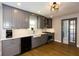 Stylish kitchen with gray cabinetry, white countertops, stainless steel appliances, and hardwood flooring, with a door to another room at 5369 Blue Grass Ln, Sugar Hill, GA 30518
