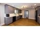 Contemporary kitchen with gray cabinets, white countertops, stainless steel appliances, and hardwood floors leading to another room at 5369 Blue Grass Ln, Sugar Hill, GA 30518