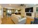 Open concept living area with hardwood floors, a fireplace, modern lighting, and a view of the kitchen and dining area at 5369 Blue Grass Ln, Sugar Hill, GA 30518
