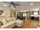 Spacious living room with hardwood floors, a comfortable sectional sofa, and an open view to the dining area and kitchen at 5369 Blue Grass Ln, Sugar Hill, GA 30518