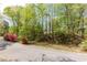 Picturesque street view with vibrant azaleas adding color to the lush greenery and wooded landscape at 5369 Blue Grass Ln, Sugar Hill, GA 30518