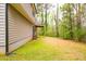 A view of the home's exterior and backyard, featuring a raised deck and wooded surroundings at 7617 Lakemoor Dr, Riverdale, GA 30296