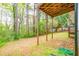 View under the deck in the backyard area with mature trees and a lush green lawn at 7617 Lakemoor Dr, Riverdale, GA 30296