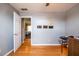 Bedroom with hardwood floors, with an open door leading into another room, and mounted wall storage at 7617 Lakemoor Dr, Riverdale, GA 30296